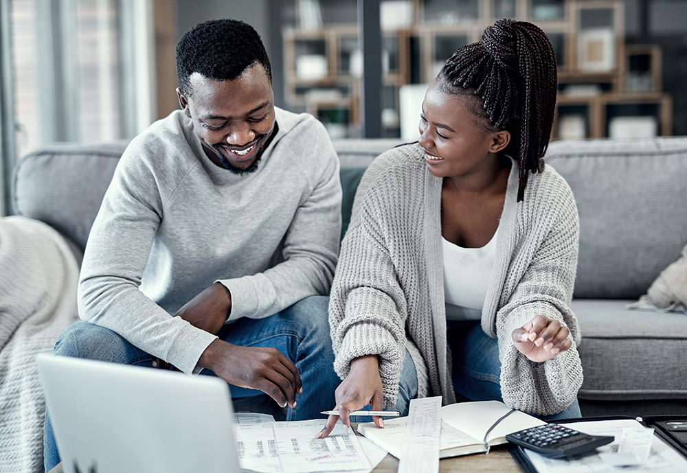 Finance, home budget and financial planning with a couple working on a laptop looking happy about savings, investment and mortgage insurance. Boyfriend and girlfriend calculating tax or future